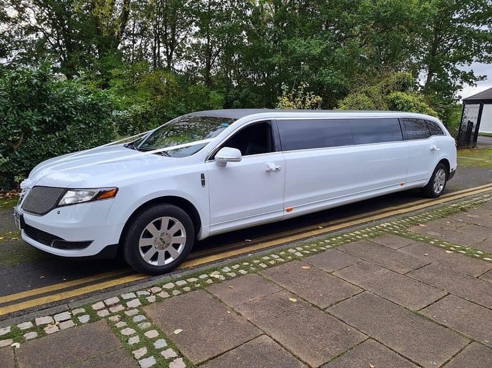 Lincoln MKT white limo with wedding ribbons