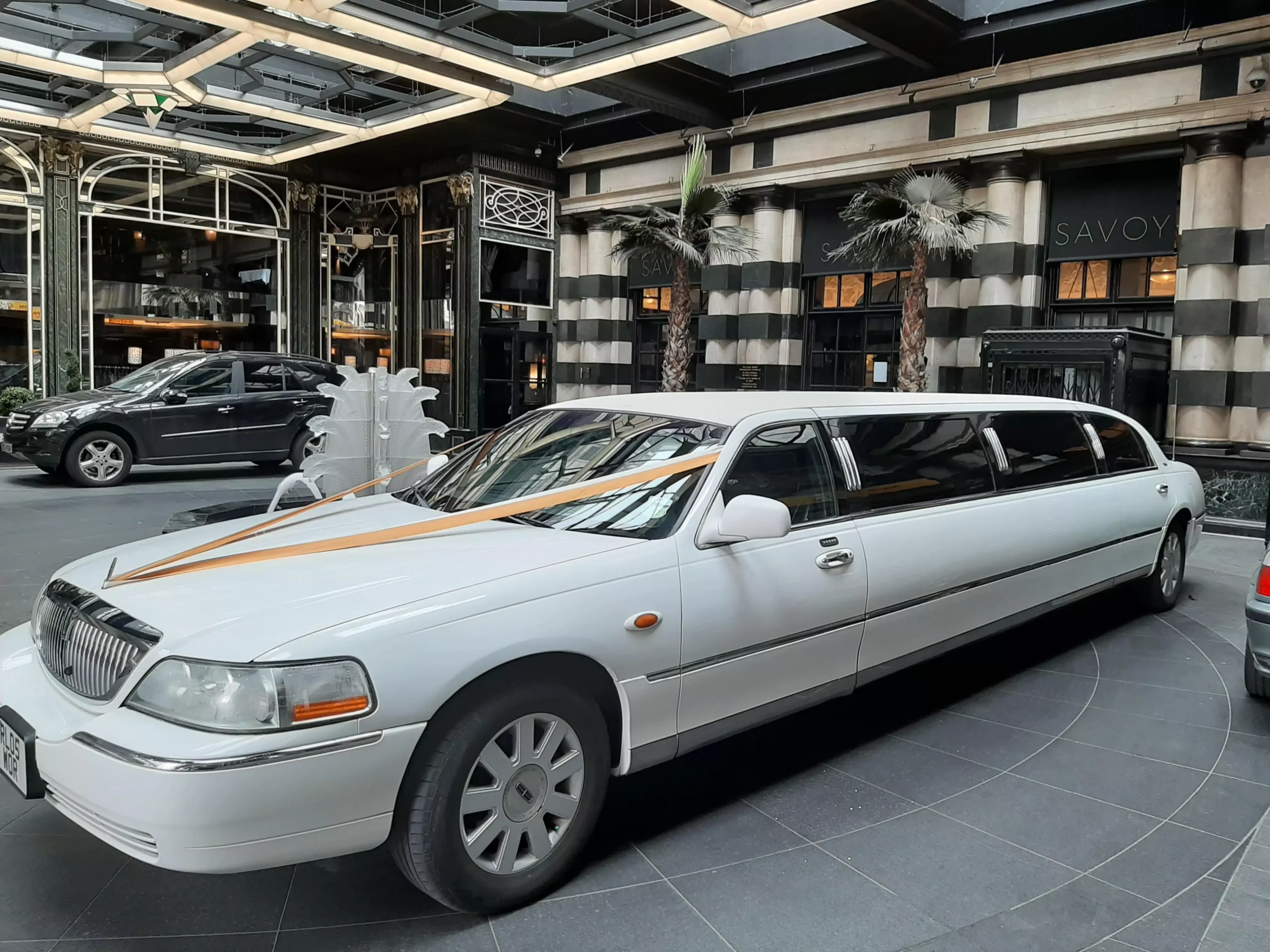 white lincoln town car limo with wedding decorations